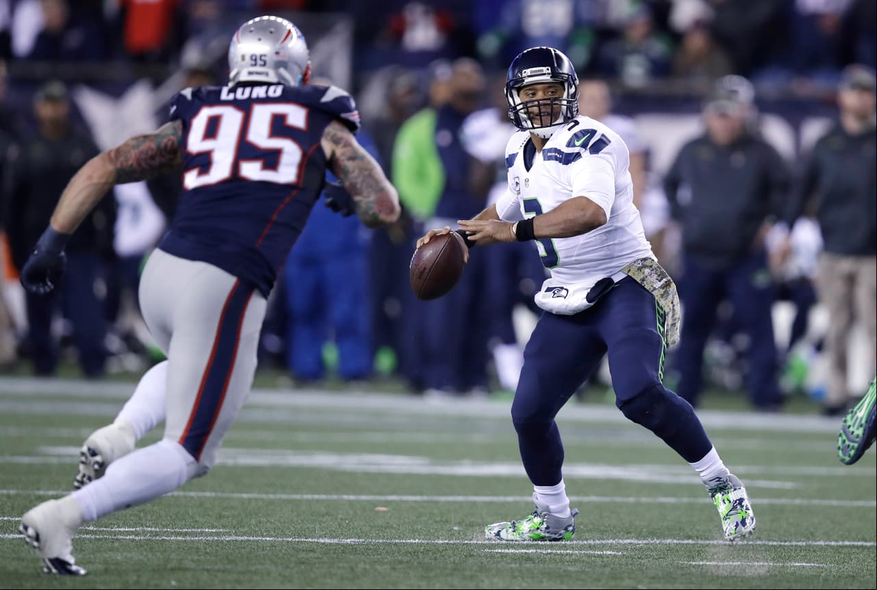 Seattle Seahawks quarterback Russell Wilson (3) throws as New England Patriots defensive end Chris Long (95) pressures the  during the second half of an NFL football game, Sunday, Nov. 13, 2016, in Foxborough, Mass. (AP Photo/Charles Krupa)